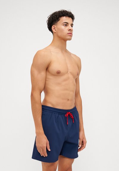 Shorts de bain bleu marine en tissu à séchage rapide, avec une taille élastique et un cordon rouge, au design simple et épuré.
