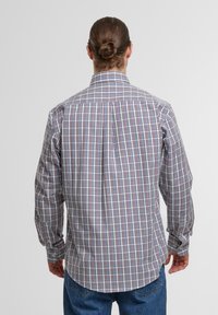 Karierte Hemd aus leichtem Stoff, mit roten, blauen und weißen Quadraten. Lange Ärmel mit Knopfmanschetten, Rückenpasse.