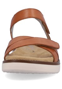 Sandale en cuir marron avec deux sangles réglables. Semelle intérieure douce et texturée sur une semelle de couleur claire, avec un profil bas et un design minimaliste.