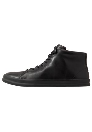 Zwarte hoge sneakers van soepel leer met een ronde neus, voorzien van een platte rubberen zool en vetersluiting.