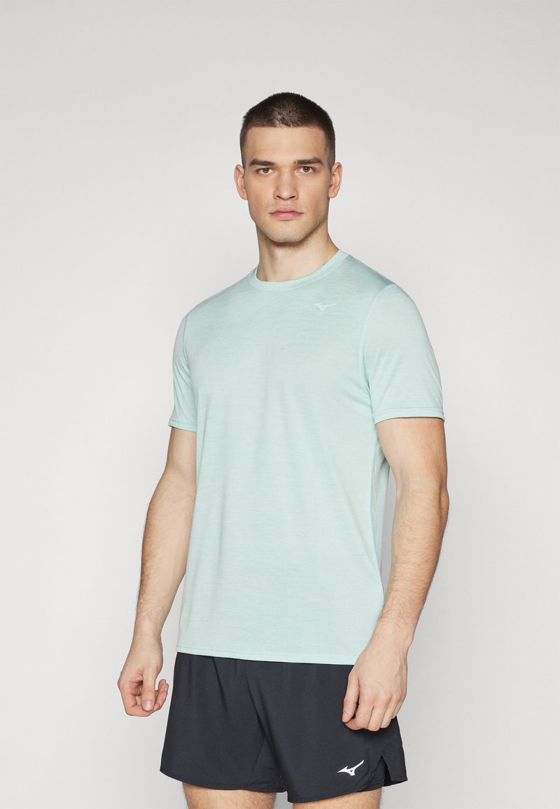 Camiseta deportiva de color azul claro hecha de una tela suave, con cuello redondo y mangas cortas. Un pequeño logo blanco está ubicado en la parte superior izquierda del pecho.