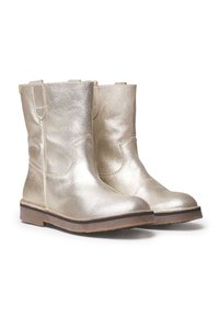 Botas de tobillo metálicas doradas con una textura suave, punta redondeada y una suela baja marrón. Cuenta con tiradores a los lados para facilitar el calzado.