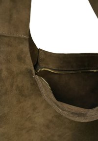 Braune Wildleder-Shopper-Tasche mit Reißverschluss. Verfügt über eine glatte Textur und klare Linien, die das Innere und die Details der Nähte hervorheben.