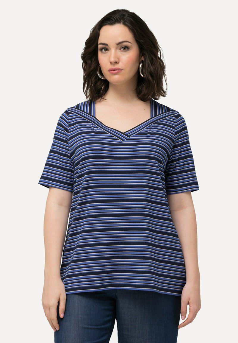 Pruhovaný top s krátkým rukávem na námořnickém pozadí se světle modrými a bílými pruhy, s výstřihem do V a uvolněným střihem.