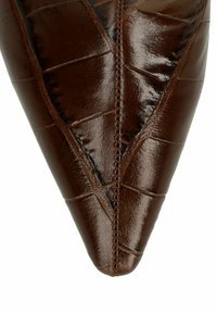 Chaussure en cuir marron à bout pointu avec une finition brillante, arborant des détails texturés et cousus ainsi qu'un design épuré.
