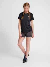 Svart kortärmad träningsskjorta med en strukturerad design, kombinerad med mörkgrå shorts som har en gul logotyp på sidan. Svarta löparskor.