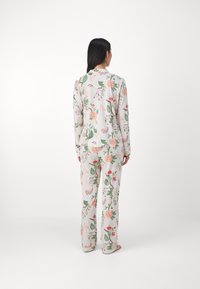 Floral pajama set featuring long sleeves and pants, made of soft fabric with a light-colored background and a pattern of various flowers and leaves.