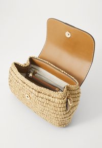 Woven straw handbag with a tan leather interior, featuring a zipper pocket, gold hardware, and a button closure. Open design displays interior.