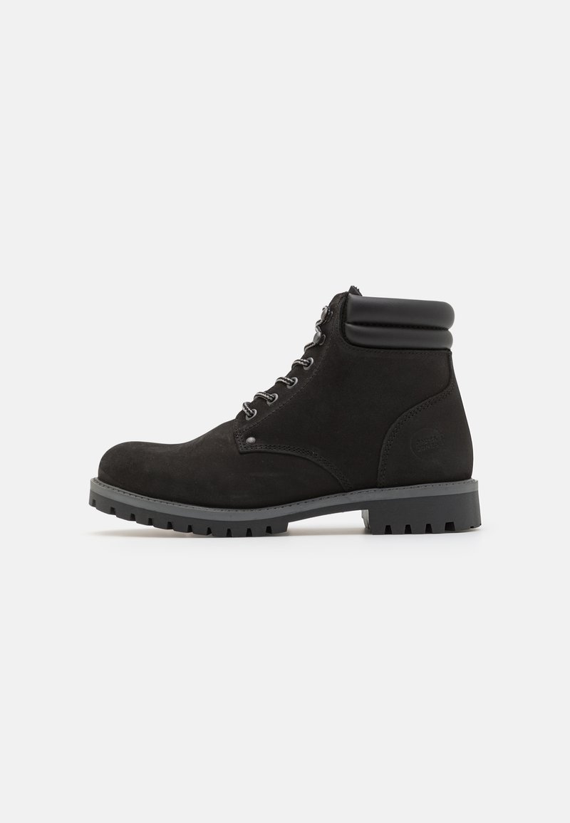 Botín de ante negro con un collar acolchado, suela de goma gris, puntera redonda y ojales metálicos para los cordones. Parte superior texturizada y diseño duradero.