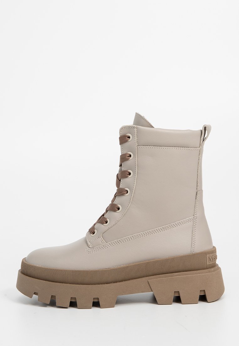 Beige Kunstleder Stiefeletten mit braunen Schnürsenkeln, kräftiger brauner Gummisohle und einem Zugriemen hinten für einfaches Anziehen.