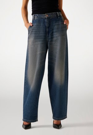 Jeans a gamba larga in denim blu scuro, con una finitura sbiadita, due tasche laterali e vita alta. Accentuati da un bottone metallico in vita.