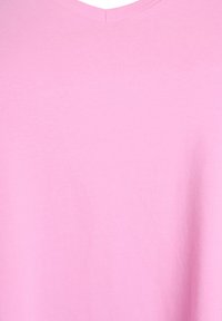 Camiseta de manga corta con cuello en V en suave tela de algodón rosa, que presenta una textura lisa y un diseño simple y sin adornos.