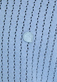 Suéter de punto azul claro con rayas verticales, que presenta un patrón texturizado y un pequeño logo bordado en la esquina inferior izquierda.