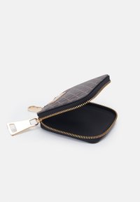 Svart dragkedjebehållare med krokodiltextur, guldfärgade detaljer och svart inredning. Har en slät dragkedja och en kompakt design.