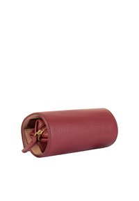 Clutch rotondo in pelle color bordeaux con una finitura texture, dotato di una chiusura con zip dorata e un piccolo tirazip in pelle. Interno color beige.