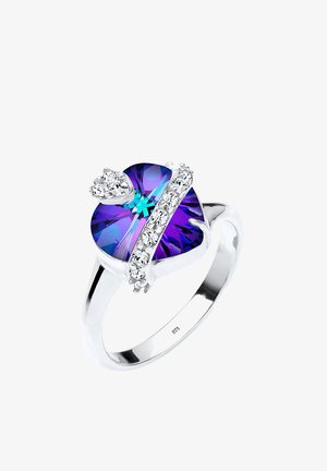 Sølvring med et hjerteformet lilla krystal med blå accenter, omgivet af klare sten langs bæltet. Markeret 925.