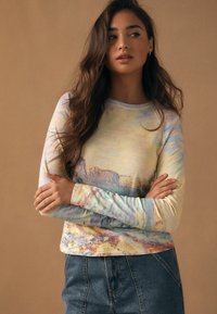 Pikad varrukad särk, millel on pehme, pastelse tooniga abstraktne muster ja keha järgi vormiv lõige. Kangas on kerge ja sile ning sobib kõrge vöökohaga teksadega.