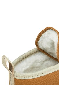 Brown leather slipper with a soft cream lining. Features a beige textile edge and a small loop for easy wearing.