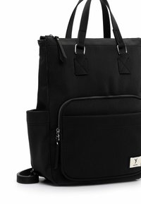 Svart tote-väska med en texturerad ribbad design, zippered huvudfack, framficka och justerbar axelrem. Silverdetaljer.