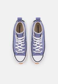 Lila canvas högskaftade sneakers med vita snören, svarta accenter och vita gummisulor. Har rund tå och strukturerad tyg.