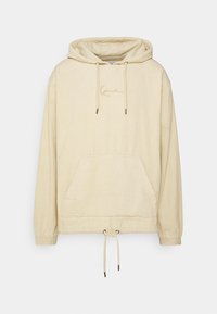 Sudadera de pana en beige claro con un bolsillo tipo canguro, capucha con cordón y un sutil bordado en el pecho.