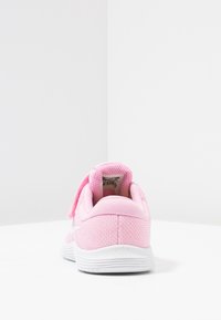 Růžová sportovní bota s síťovinovým svrškem, suchým zipem a bílou gumovou podrážkou. Texturovaný podpatek a decentní značení na boku.