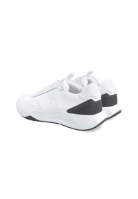 Zapatillas deportivas blancas con un upper de malla texturizada y suela de goma sólida. Presentan una marca prominente y un diseño minimalista con acentos negros.