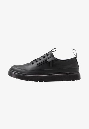 Czarny niski skórzany sneaker z grubą podeszwą, sznurowaniem z przodu, zamkiem bocznym i pętelkami na języku i pięcie.
