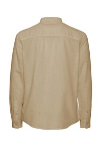 Camisa de manga larga beige, hecha de tejido texturizado, con cuello estándar, puños con botones y una parte trasera lisa sin adornos.