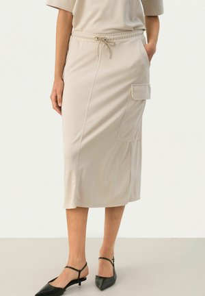 Jupe beige mi-longue en tissu doux, dotée d'une taille élastique avec cordon et d'une poche latérale. Texture lisse.