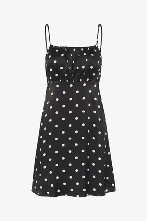 Melnas bezpiedurkņu kleitas ar baltām punktiņām, kurai ir sakrauta augšdaļa un plūstoša svārku daļa. Izgatavota no gludas, vieglas auduma.