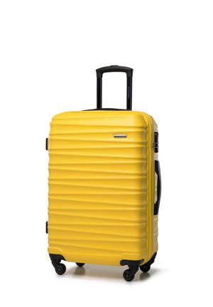 Hard-shell yellow suitcase with textured vertical ridges, black wheels, a extendable handle, and a brand emblem on the front.