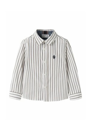 Chemise blanche à manches longues et boutonnée, avec de fines rayures verticales brunes, un col pointu et un petit écusson sur la poitrine.