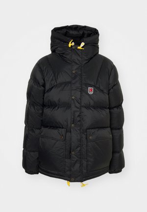 Doudoune noire en nylon brillant, dotée d'une capuche, de deux poches avant et d'accents en cordon jaune. Comprend un badge logo sur la poitrine.