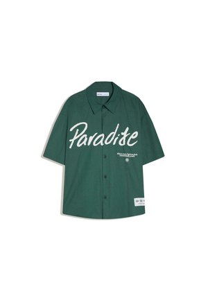 Zelená košeľa s krátkym rukávom na gombíky s veľkým bielym nápisom "Paradite" a malým bielym textom a záplatou na prednej pravej strane.