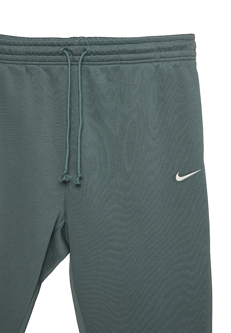 Graugrüne Nike-Sweatpants mit elastischem Bund, Kordelzug und Logo-Akzent. Glatte Stoffstruktur mit Seitentaschen.