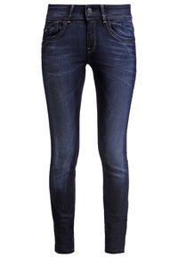 Jeans skinny de un azul oscuro, hechos de denim, con cierre de botón, cinco bolsillos y sutiles detalles de desvanecimiento en la parte frontal.