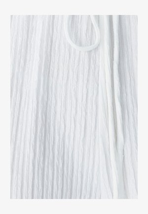 Biela textúrovaná tkanina s vertikálnymi rebrami, zdobená tenkým šnúrkovým pásom a jemným, ľahkým vzhľadom.