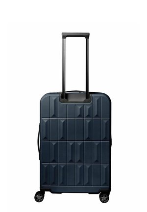 Valise rigide bleu marine à motif géométrique, poignée télescopique noire étendue, quatre roues et poignée de transport latérale.