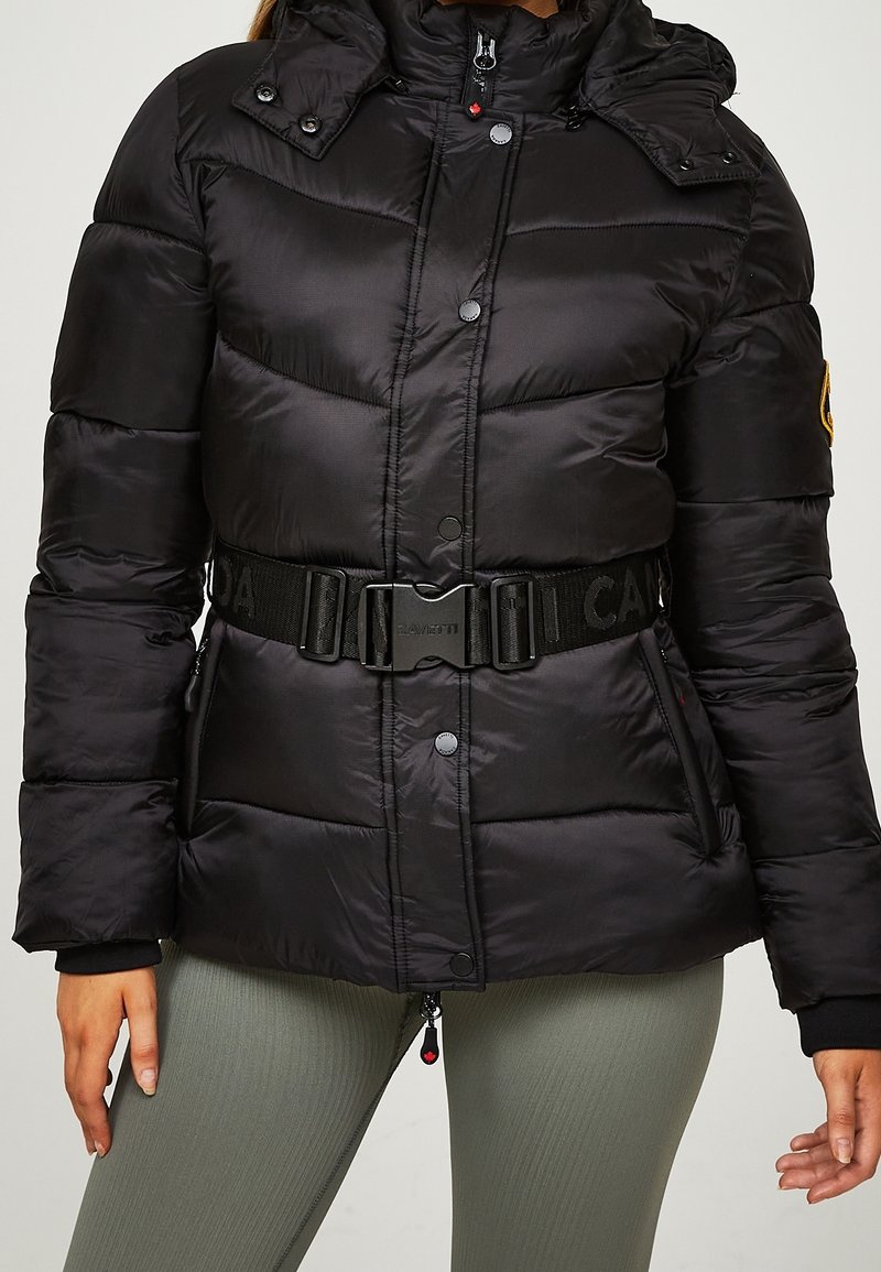 Chaqueta acolchada negra con capucha, que presenta una cintura ceñida con cinturón, botones a presión y un acabado texturizado. Acentuada con un parche de logo y detalles en cremallera.