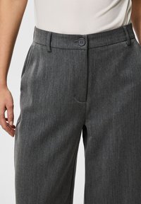 Pantaloni grigi su misura con una texture liscia, vestibilità dritta e chiusura con bottone in vita. Include tasche laterali.
