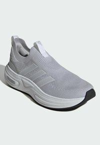 Grå träningsskor med en slip-on-design, ovandel i mesh, texturerad yta, tre-randiga detaljer och en dämpad vit sula med en svart tå.