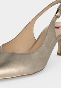 Πέδιλο Slingback από μεταλλικό δέρμα σε χρυσό χρώμα με χαμηλό τακούνι και χρυσή πόρπη.