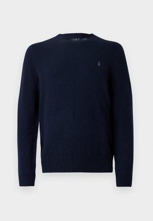 Sweater malha azul marinho com gola redonda, punhos e bainha canelados. Apresenta um pequeno logótipo bordado no lado esquerdo do peito. Textura macia.