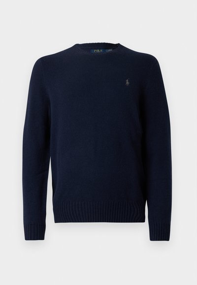 Sweater malha azul marinho com gola redonda, punhos e bainha canelados. Apresenta um pequeno logótipo bordado no lado esquerdo do peito. Textura macia.