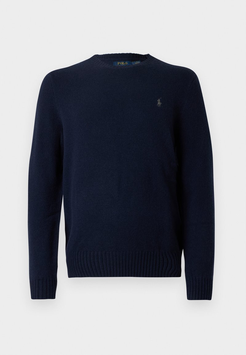 Navyblauwe gebreide trui met een ronde hals, geribbelde manchetten en zoom. Voorzien van een klein geborduurd logo op de linkerkant van de borst. Zachte textuur.