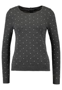 Szary sweter z długim rękawem, z dekoltem w kształcie łódki i wzorem białych kropek na całej powierzchni. Wykonany z miękkiej dzianiny z prążkowanymi mankietami.