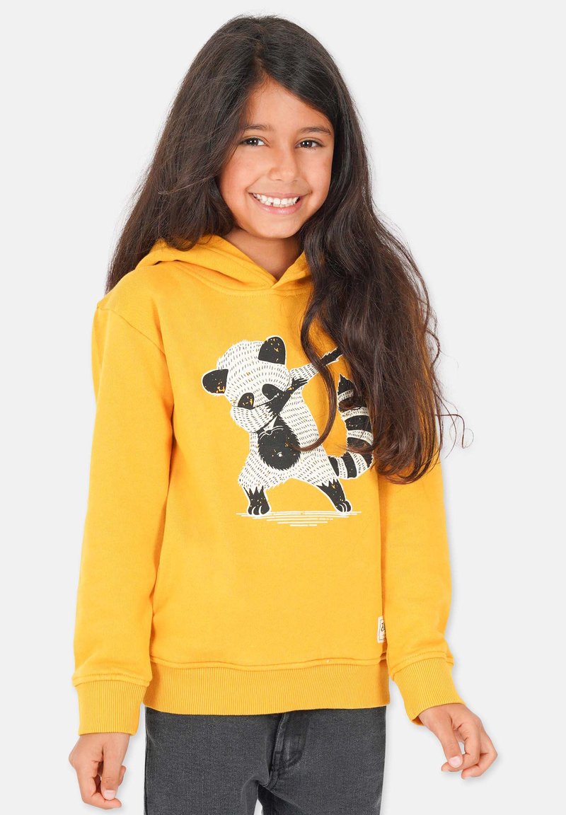 Gul huvtröja med en panda-grafik. Mjukt material, ribbad mudd och nederkant. Bärs över mörkgrå byxor.