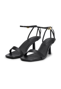 Sandali con tacco in pelle nera, caratterizzati da sottili cinturini e un design con punta quadrata. Presentano un elegante tacco a spillo e un piccolo dettaglio con fibbia dorata.