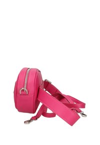 Ronde, roze schoudertas van kunstleer, met een zilveren rits en een verstelbare riem. De tas heeft een gladde textuur en een compact ontwerp.
